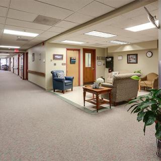 A spacious hallway with a waiting area featuring comfortable seating and decor.
