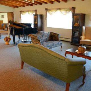 A spacious living room with elegant furniture and a grand piano.