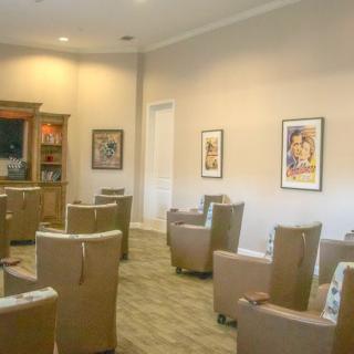 A calm waiting room with comfortable chairs and artwork on the walls.