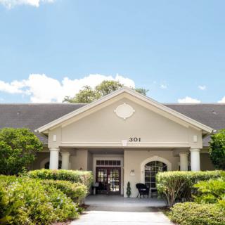 A charming residential building with an inviting entrance surrounded by lush greenery.