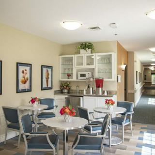 A modern and inviting dining area with tables, chairs, and a kitchenette in the background.