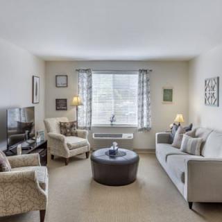 A cozy living room with a sofa, armchairs, and a round coffee table.