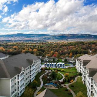 Aerial view of a picturesque resort surrounded by lush greenery and mountains.