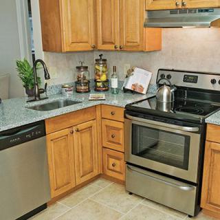 A modern kitchen with stainless steel appliances and wooden cabinetry.