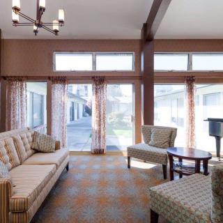 A cozy living room with modern furniture and large windows letting in natural light.