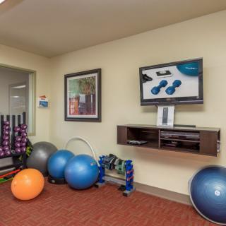 A small gym area featuring stability balls, dumbbells, and other exercise equipment.