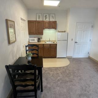 A compact kitchen with a small dining table, chairs, and essential appliances.