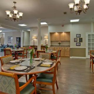 A spacious dining area with neatly set tables and elegant chandeliers.