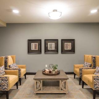 A cozy living room with stylish chairs, a central coffee table, and decorative wall art.