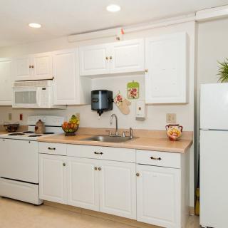 A bright kitchen featuring white cabinets, modern appliances, and a clean countertop.