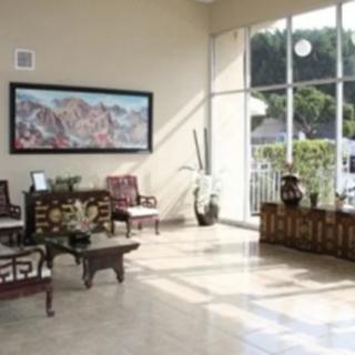 A bright and spacious lobby with seating, large windows, and artwork on the wall.