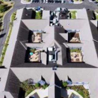 Aerial view of a series of connected buildings with distinct rooftop layouts.