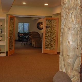 A hallway featuring carved wooden doors and a decorative pillar.