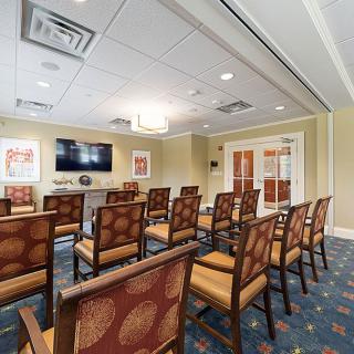 A well-organized conference room with rows of chairs facing a television screen.
