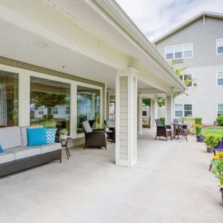 A spacious outdoor patio with comfortable seating and a view of the garden.