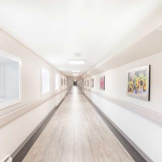 A bright and clean hospital corridor with artwork on the walls.