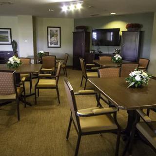 A well-appointed meeting room with tables and chairs arranged for discussions, featuring decorative flower arrangements.