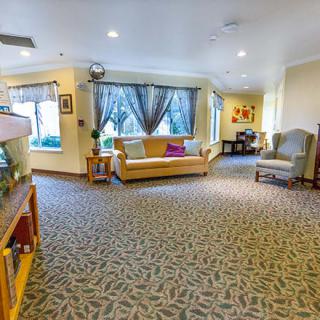 A cozy lobby area with sofas, chairs, and large windows.