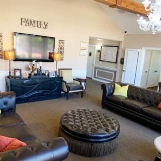 A cozy living room with leather sofas, a television, and decorative elements.