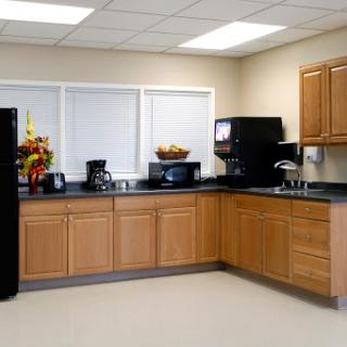 A modern kitchen featuring wooden cabinets, essential appliances, and a clean, organized layout.