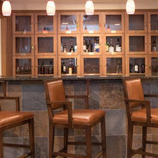 A stylish bar setup with high chairs and a well-lit counter.