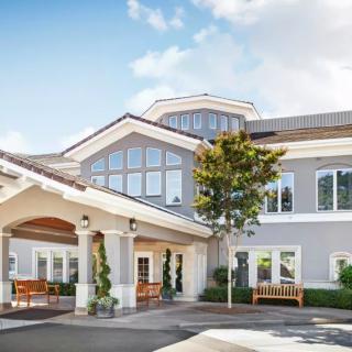Exterior view of a modern suburban building with large windows and a covered entrance.