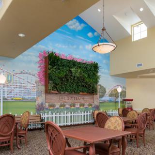 A dining area featuring a vibrant wall mural of a sky, with an indoor vertical garden and comfortable seating.