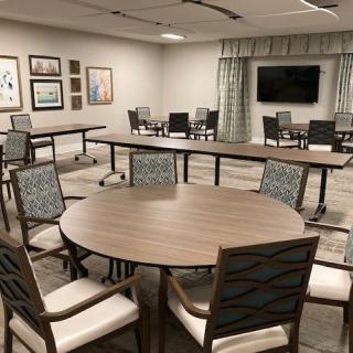 A modern conference room with tables and chairs arranged for a meeting.