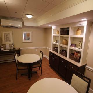 A cozy dining area with round tables, chairs, and decorative shelving.