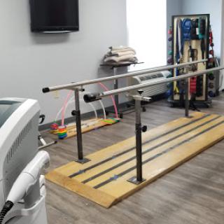 A physical therapy room equipped with parallel bars for patient rehabilitation.