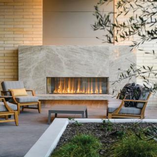 A modern outdoor patio featuring a sleek fireplace and comfortable seating.
