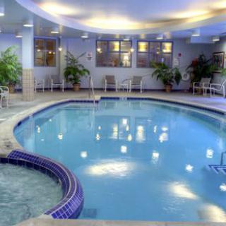 A luxurious indoor swimming pool with seating and ambient lighting.