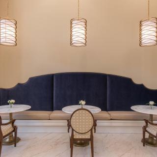 Elegant restaurant seating area with pendant lights and upholstered benches.