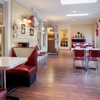 A retro-style diner interior with booths and tables, featuring classic decor.