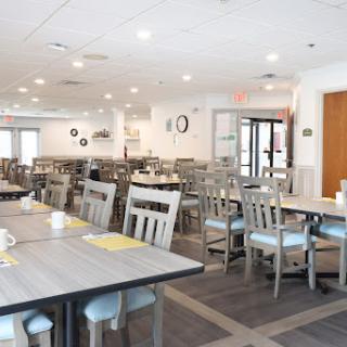 A spacious and well-lit dining area featuring modern furniture and a clean aesthetic.