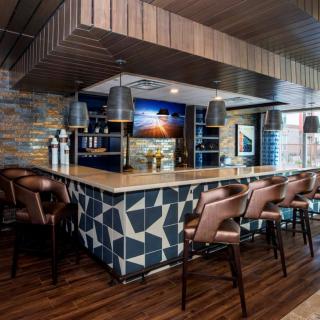 A modern bar interior with a stylish counter and comfortable seating.