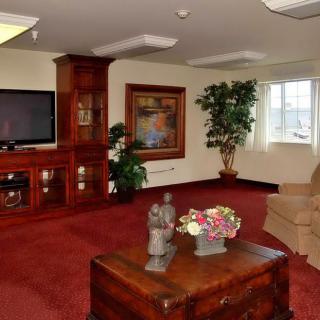 A well-appointed living room with a television, wooden furniture, and decorative elements.