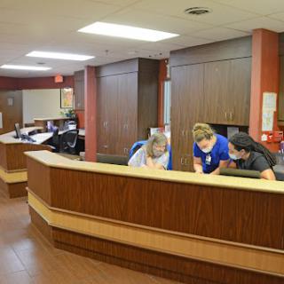Healthcare staff collaborating at the reception desk in a hospital.