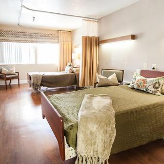 A cozy bedroom featuring twin beds with modern decor and ample natural light.