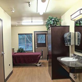 A well-lit interior featuring a bathroom with a sink, mirror, and decorative plants.