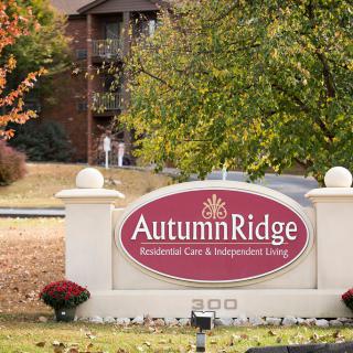 Sign for Autumn Ridge Residential Care and Independent Living surrounded by trees.