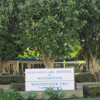 A sign in front of the Extended Care Hospital of Westminster, surrounded by trees.