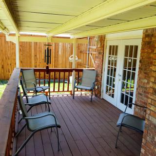 A cozy outdoor patio with seating and a wooden deck.