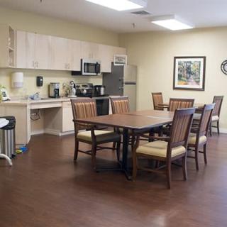 A spacious kitchen and dining area with a wooden table and chairs, equipped with modern appliances.