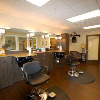 A modern barbershop interior with barber chairs and mirrors.