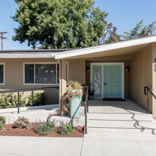 A modern residential house with a landscaped front yard and a welcoming entrance.