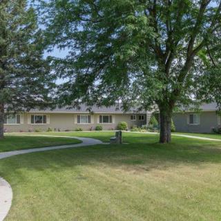 A suburban house with a well-maintained yard and trees.