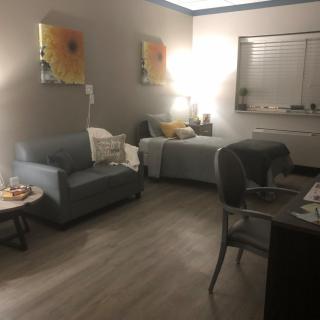 A cozy living space with a sofa, bed, and warm lighting.