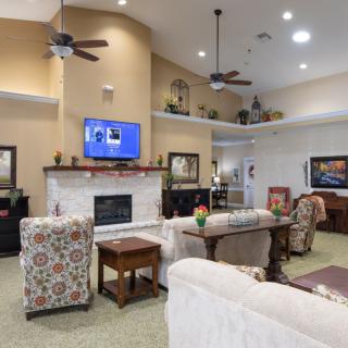 A spacious living room featuring comfortable seating, a fireplace, and a wall-mounted television.