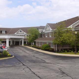 A welcoming hotel entrance with a landscaped drive and a clear sky.